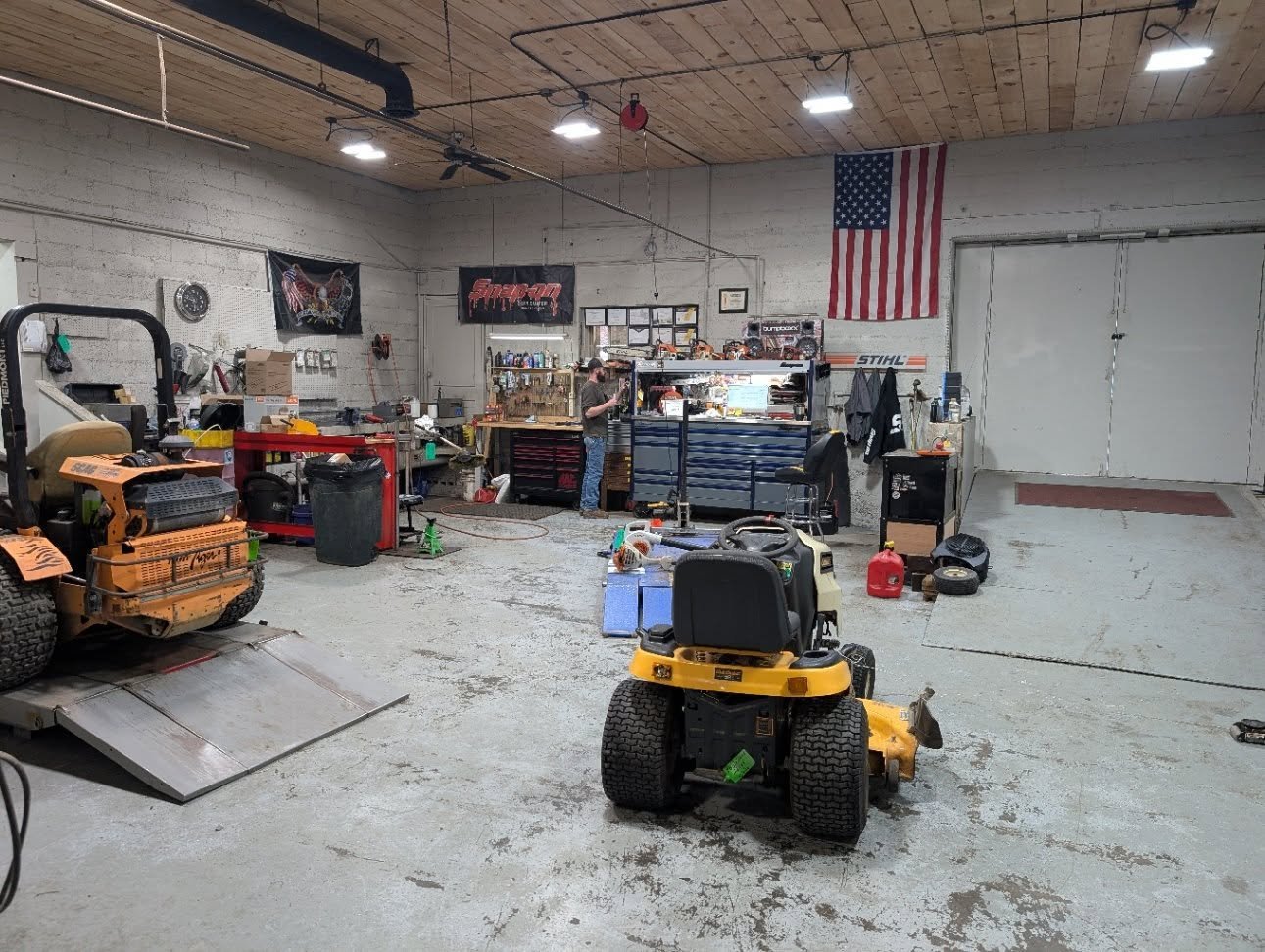 Evergreen Equipment service garage with outdoor power equipment ready for repair